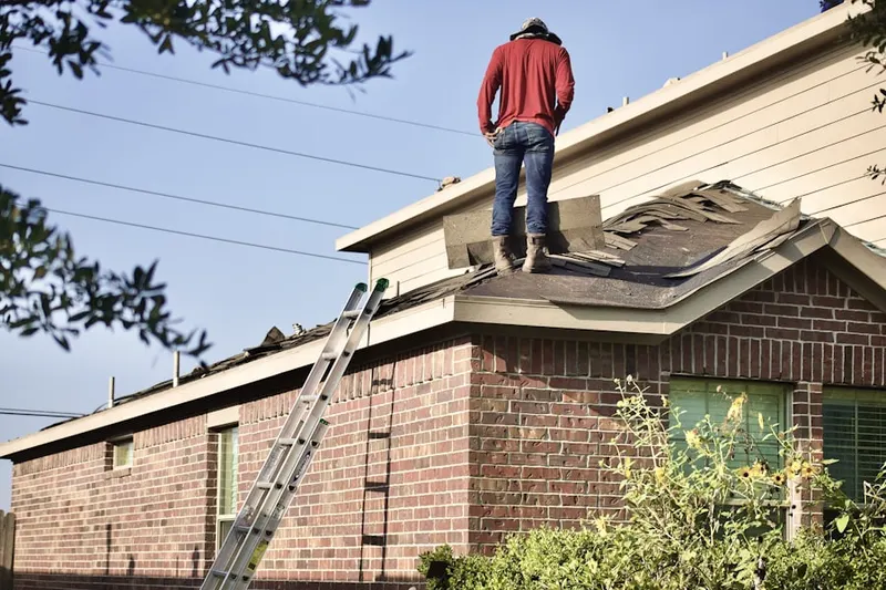 Professional roofer working on a residential roof in Cobb